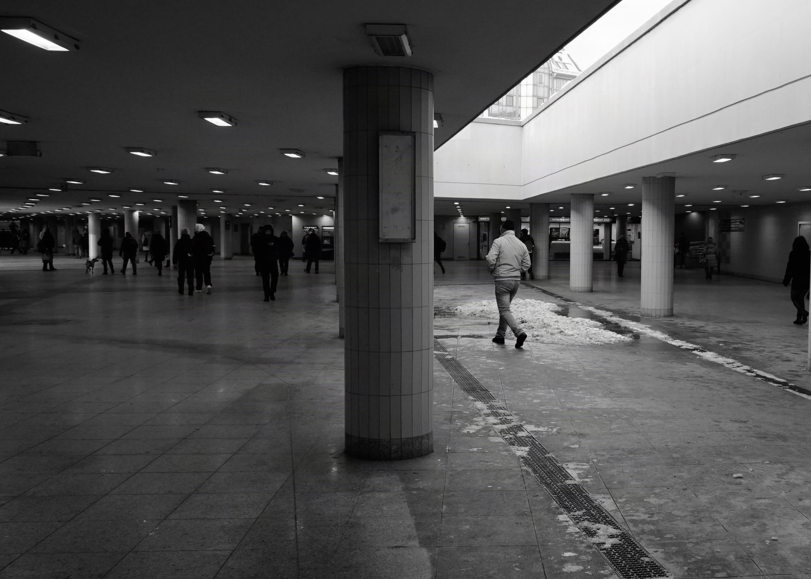 Black and white picture underground, with light coming from a hole in the ceiling.